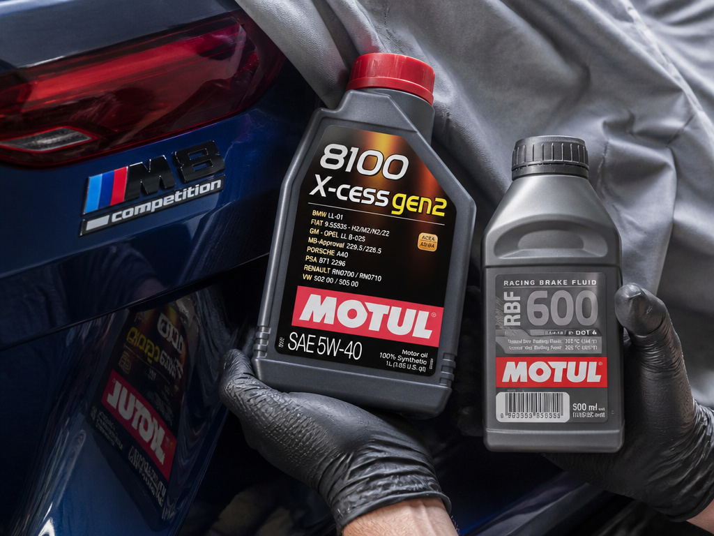 Essential BMW M8 Competition maintenance items: engine oil, brake fluid, and car cover.